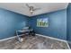 Blue office space with a ceiling fan, neutral floors, and a desk with a backyard view at 3104 Garbett Ter, North Port, FL 34288