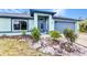 Beautiful front yard with modern blue home, landscaping, flowerbeds and well maintained lawn at 3104 Garbett Ter, North Port, FL 34288