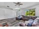 Spacious living room featuring wood floors, a ceiling fan, and a comfortable sectional sofa at 3104 Garbett Ter, North Port, FL 34288