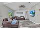 Bright living room showcasing wood floors, modern decor, a ceiling fan, and a brown leather sectional sofa at 3104 Garbett Ter, North Port, FL 34288