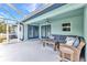 Cozy screened-in patio with comfortable seating, ceiling fan, and views of the backyard at 3104 Garbett Ter, North Port, FL 34288