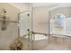 Bathroom features a glass-enclosed shower and soaking tub with a window and bench at 3520 Caya Largo Ct, Punta Gorda, FL 33950