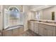 A well-lit bathroom has double vanities, a granite countertop, and a window seat with natural light at 3520 Caya Largo Ct, Punta Gorda, FL 33950