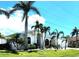 Beautifully landscaped front of the home with lush lawn, palm trees and large picture windows at 3520 Caya Largo Ct, Punta Gorda, FL 33950