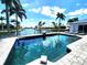 Tranquil pool view with clear water, palm trees, and sunny skies, reflecting the serene waterfront living this home offers at 3520 Caya Largo Ct, Punta Gorda, FL 33950