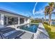 A beautiful backyard pool is surrounded by lounge chairs and bordered by lush tropical landscaping and tranquil canal views at 3520 Caya Largo Ct, Punta Gorda, FL 33950