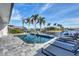 Gorgeous pool with waterfront access and beautiful palm tree landscaping on a bright, sunny day at 3520 Caya Largo Ct, Punta Gorda, FL 33950