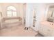 Serene bathroom featuring a garden tub, dual sinks, and natural light from an arched window at 3787 Whippoorwill Ct, Punta Gorda, FL 33950