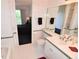 Bright bathroom with tile floor, white cabinets and green trim, leading to bedroom at 3787 Whippoorwill Ct, Punta Gorda, FL 33950