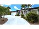 Luxury home with a tile roof, prominent columns, and lush tropical landscaping at 3787 Whippoorwill Ct, Punta Gorda, FL 33950