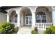 Welcoming front porch with white pillars, arched windows, decorative balustrade, and a double door entry at 3787 Whippoorwill Ct, Punta Gorda, FL 33950