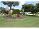 Landscaped front yard features a large palm tree surrounded by tropical shrubbery at 3787 Whippoorwill Ct, Punta Gorda, FL 33950