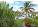 Scenic water view featuring lush greenery, vibrant flowers, palm trees and boat dock at 3787 Whippoorwill Ct, Punta Gorda, FL 33950