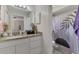 Bathroom with a white vanity, granite countertop, and modern shower curtain at 4129 Palisades Ave, North Port, FL 34287