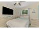 Comfortable bedroom features a ceiling fan, a large window, and a dresser with a TV at 4129 Palisades Ave, North Port, FL 34287