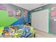 Bedroom featuring light wood floors, ceiling fan, closet, and colorfully painted walls at 4129 Palisades Ave, North Port, FL 34287