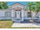 Welcoming front entrance with a decorative door, complemented by large windows and a meticulously kept lawn at 4129 Palisades Ave, North Port, FL 34287