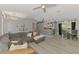 Open-concept living space with a large gray sectional sofa, connecting to the dining area and kitchen at 4129 Palisades Ave, North Port, FL 34287