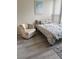 Cozy bedroom featuring an accent chair, floral-patterned bed, and wood-look floors, creating a peaceful retreat at 618 Bird Bay S Dr # 109, Venice, FL 34285