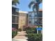 Exterior view of the Sandpiper building with lush landscaping and a walkway leading to the entrance at 618 Bird Bay S Dr # 109, Venice, FL 34285