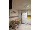 Cozy eat-in kitchen with white cabinetry, appliances, yellow countertops, and a charming breakfast nook at 618 Bird Bay S Dr # 109, Venice, FL 34285