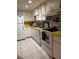 Bright kitchen featuring white appliances and cabinetry with durable yellow countertops at 618 Bird Bay S Dr # 109, Venice, FL 34285