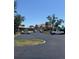 Exterior shot of the parking lot in front of the building on a clear, sunny day at 618 Bird Bay S Dr # 109, Venice, FL 34285