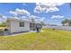 Well-maintained backyard with lush grass, BBQ grill, and white vinyl fence at 6309 Pontiac Ln, North Port, FL 34287