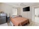 The bedroom features a ceiling fan, a mini fridge, and a view into the hallway at 6309 Pontiac Ln, North Port, FL 34287