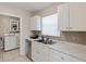 The kitchen has white cabinets, stainless appliances, and a view into the laundry room at 6309 Pontiac Ln, North Port, FL 34287