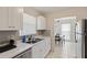 This kitchen features white cabinets, stainless steel appliances, and a view into the dining area at 6309 Pontiac Ln, North Port, FL 34287