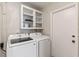 Bright laundry room with modern washer and dryer, and storage cabinets at 6309 Pontiac Ln, North Port, FL 34287
