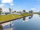 Waterfront home with a well-manicured lawn, white fence, and private dock for enjoying the water view at 6309 Pontiac Ln, North Port, FL 34287