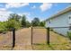 Backyard with chain-link fence and open gate, offering ample space and potential for customization and outdoor enjoyment at 7122 Turner St, Englewood, FL 34224