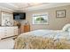 Neutral bedroom featuring a large bed, dresser, and a large window at 7122 Turner St, Englewood, FL 34224