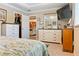 Neutral bedroom featuring a large bed, dresser, and a view to the eat-in kitchen and living room at 7122 Turner St, Englewood, FL 34224