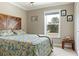 Bedroom featuring a wood headboard, bed, and a window with tree views at 7122 Turner St, Englewood, FL 34224