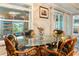 Eat-in kitchen featuring a glass dining table, custom chairs, tile floors, and a view of the screened in lanai at 7122 Turner St, Englewood, FL 34224