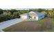 Charming single-story home with a well-manicured lawn, long driveway, an attached garage, and front garden at 7122 Turner St, Englewood, FL 34224