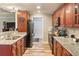 Well-lit kitchen featuring wood cabinets, granite countertops, stainless steel appliances, and wood-look tile flooring at 7122 Turner St, Englewood, FL 34224