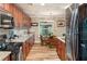 Bright eat-in kitchen featuring wood cabinets, granite countertops, stainless steel appliances, and a dining area at 7122 Turner St, Englewood, FL 34224