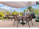 Outdoor patio with a dining table and wicker furniture, shaded by a canopy and overlooking the pool at 7122 Turner St, Englewood, FL 34224