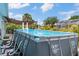 Above ground pool with ladder, surrounded by a patio and a partially screened outdoor space at 7122 Turner St, Englewood, FL 34224