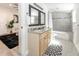 Well-lit bathroom with double vanity, granite countertop, and combination tub/shower at 7413 S Elliott St, Tampa, FL 33616