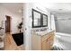 Well-lit bathroom with double vanity, granite countertop, and combination tub/shower at 7413 S Elliott St, Tampa, FL 33616