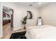 Bright bedroom with light hardwood floors, soothing decor, and access to the kitchen at 7413 S Elliott St, Tampa, FL 33616
