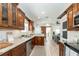An open-concept kitchen features wood cabinets, stainless steel appliances, and a view of the living room at 7413 S Elliott St, Tampa, FL 33616