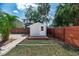 Charming backyard shed with a wooden deck, and a red stained fence at 7413 S Elliott St, Tampa, FL 33616