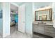 Tranquil bathroom with blue walls, modern vanity, granite countertops, and an adjoining bedroom at 8084 Burwell Cir, Port Charlotte, FL 33981
