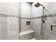 Modern bathroom showcasing tiled shower with a mosaic accent, bench, and rainfall showerhead at 8084 Burwell Cir, Port Charlotte, FL 33981